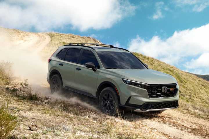Dynamic front 3/4 shot of a green 2026 Honda CR-V TrailSport off-roading.