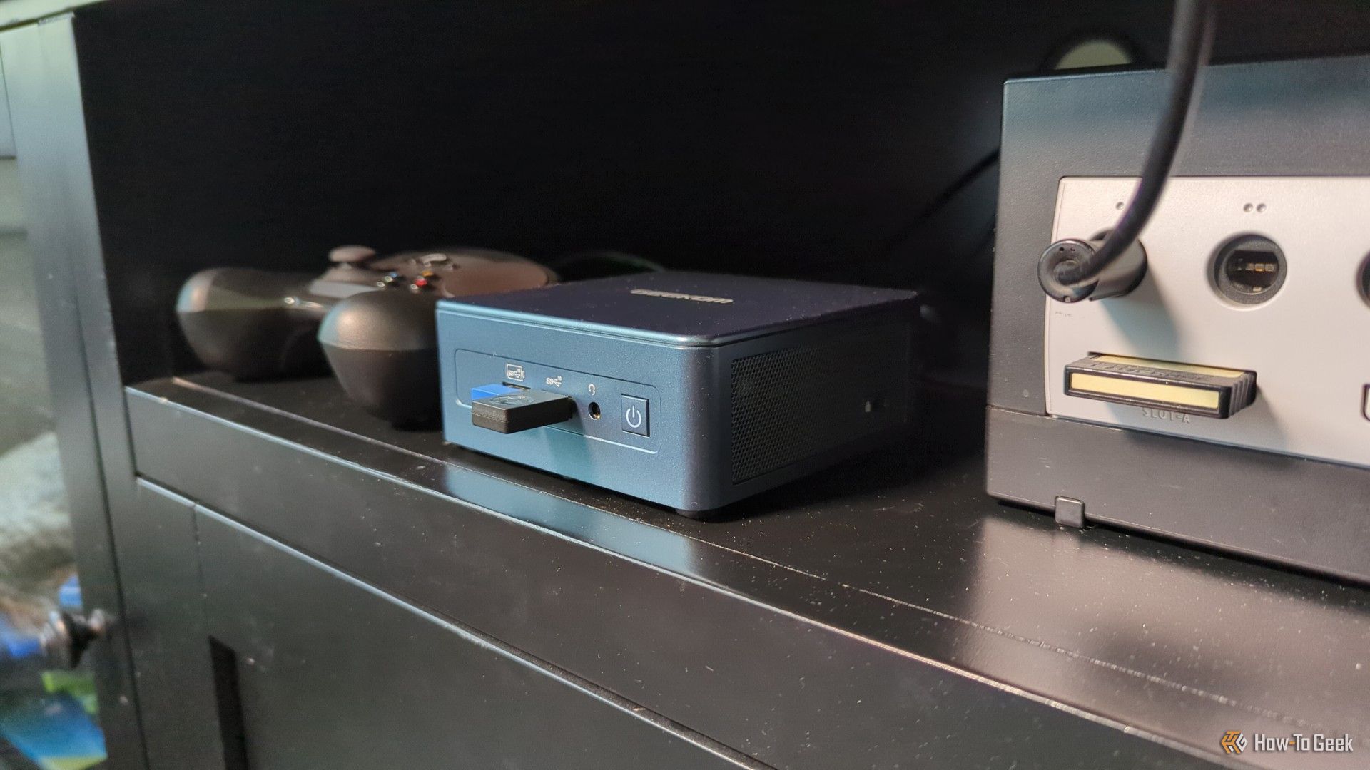 A mini PC with a Steam Controller and a Gamecube in an entertainment center.
