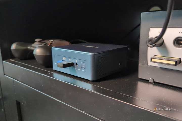 A mini PC with a Steam Controller and a Gamecube in an entertainment center.