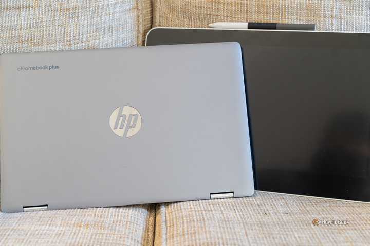 An HP Chromebook Plus sitting next to a Wacom One drawing tablet on a couch.