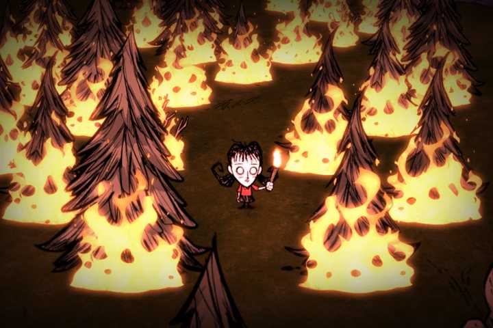 A player standing in a forest englufed in flames in Don't Starve.