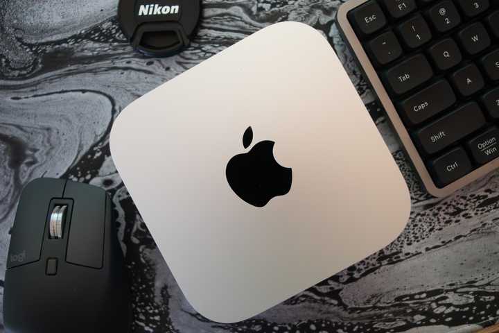 An M4 Mac Mini surrounded by a keyboard and a mouse.