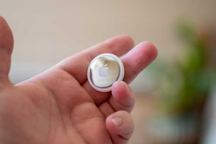 Person holding an Apple AirTag in their hand
