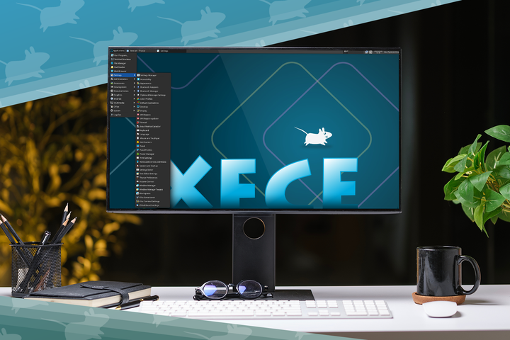 Desktop computer displaying the Xfce Linux desktop environment, set on a clean desk with a keyboard, mouse, mug, notebook, pens, sunglasses, and a potted plant.